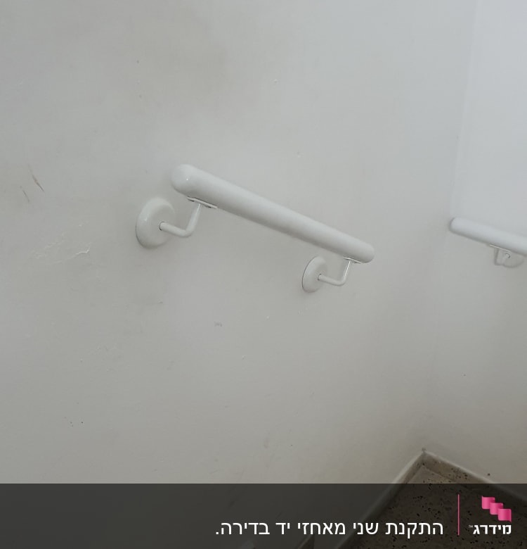 מעקה לבן מותקן על קיר מדרגות